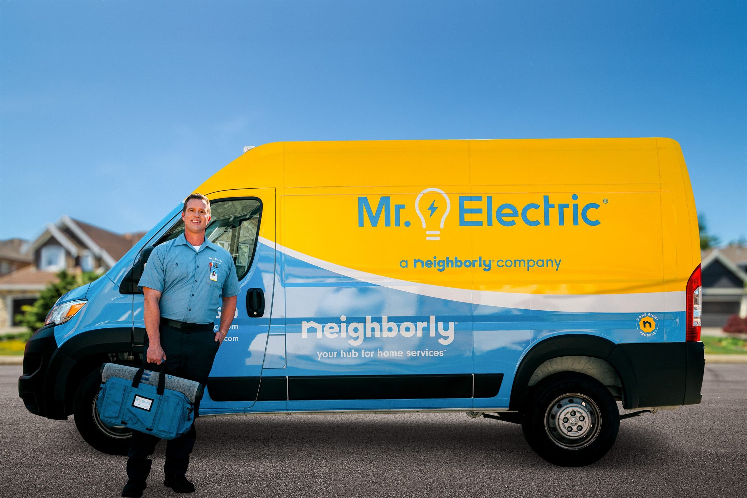 Mr. Electric technician standing in front of a branded service van