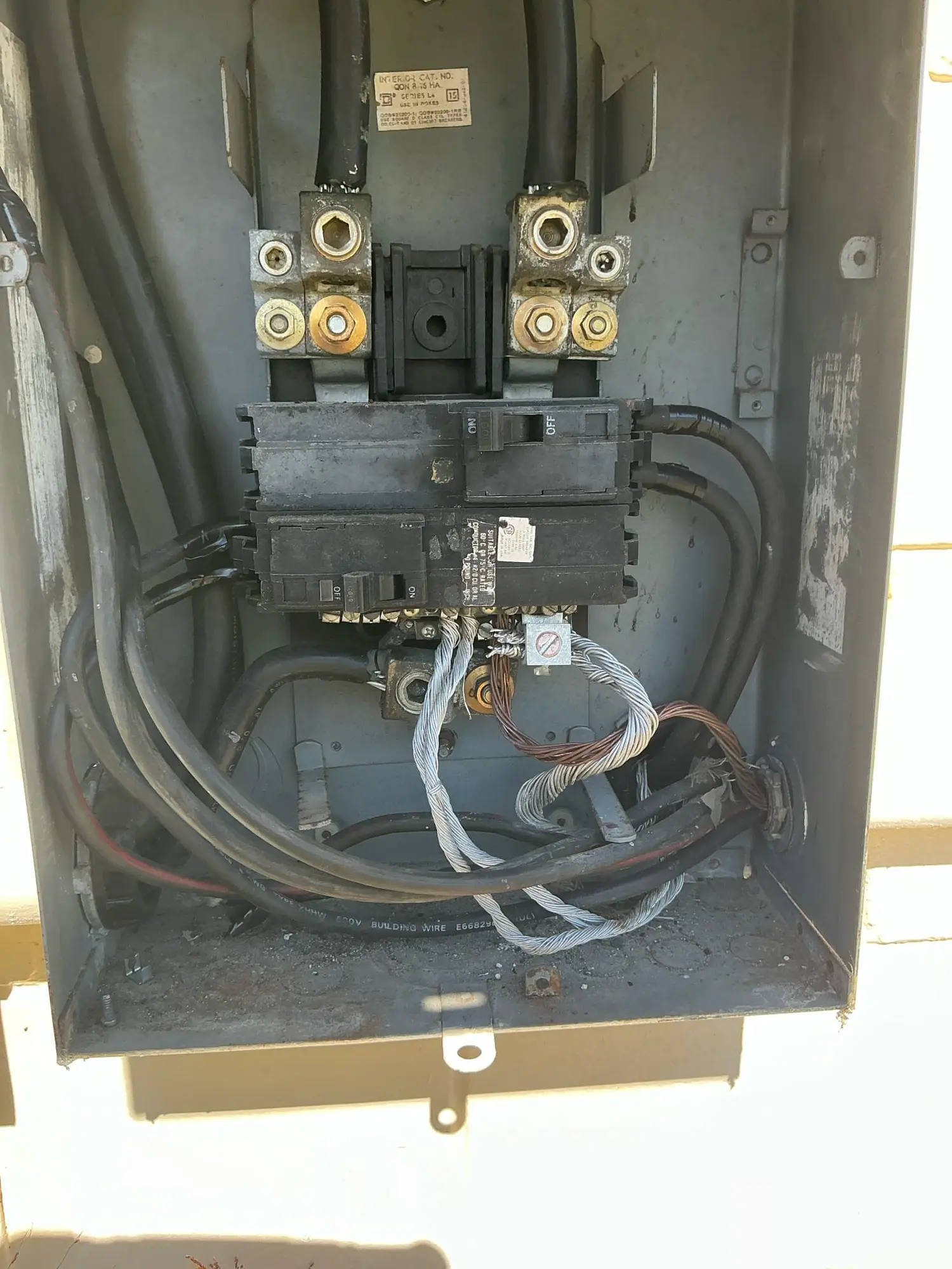 Electrical panel connections with visible heat buildup and aging components